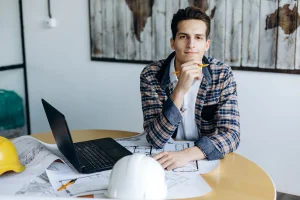 Headshot of a business guy in the office working on a drawing at his desk